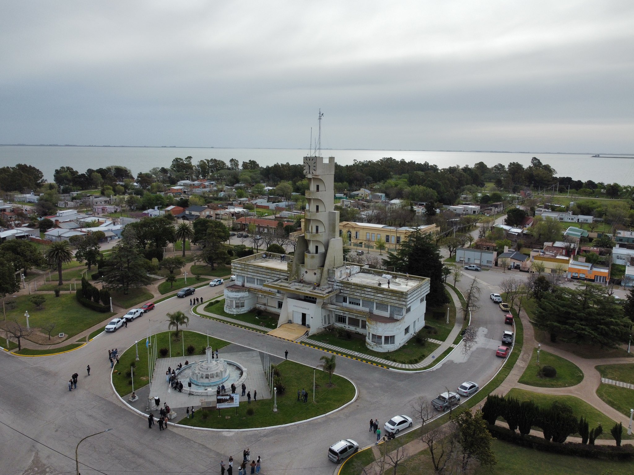 Vista aérea del Palacio Municipal de Guaminí, su torre y la fuente de la plaza, con la laguna al fondo